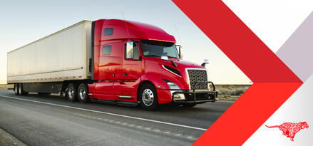 Semi truck with red cab and white intermodal container driving down the highway.