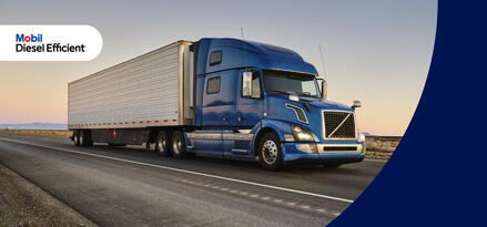 Semi truck with blue cab and white intermodal container driving down the highway.