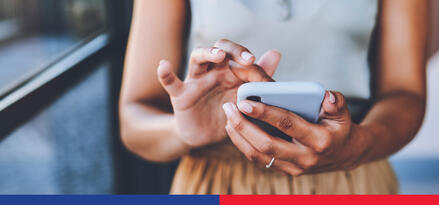 A woman is using her phone to contact ExxonMobil.