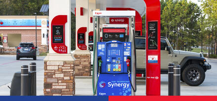 A gray SUV is fueling up at a gas station.