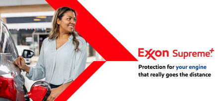 A woman in a light blue shirt is filling up her red car with text: Protection for your engine that really goes the distance. Exxon Supreme+.