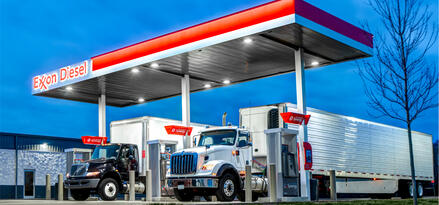 Two trucks fueling up at an Exxon branded station