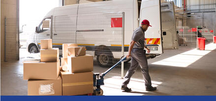 A delivery worker pulling a hand truck with boxes on it in warehouse loading area with text: Return-to-base fleets