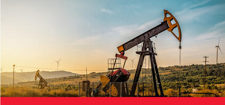 An oil drill operating in a field at sunset with text: Oil and gas drilling