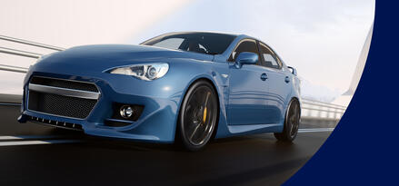 A blue car zooming down a futuristic-looking bridge.