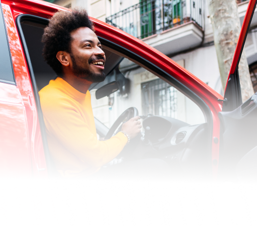 A man smiling while getting out of the driver's seat of his car.