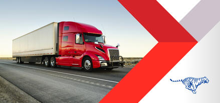 Semi truck with red cab and white intermodal container driving down the highway.