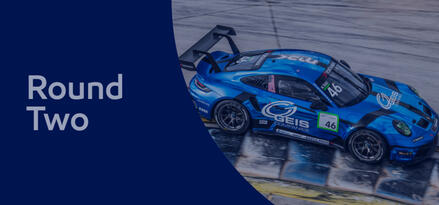 Bright blue Porsche Carrera race car from above with text: Round Two.