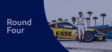Race car driver leaning against side of race car looking at camera with text: Round Four.