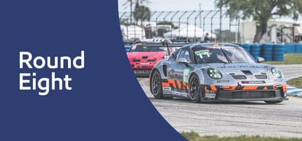 Gray Porsche Carrera race car in front of other race car in background on track with text: Round Eight.