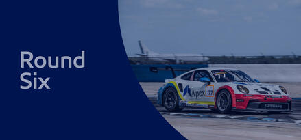 Porsche Carrera race car on track with text: Round Six. Blue sheer overlay on whole image.